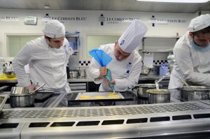 A group of people are cooking in a kitchen preparing food